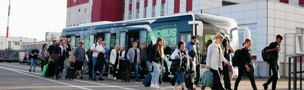 Passenger electric bus at airport with passengers walking out